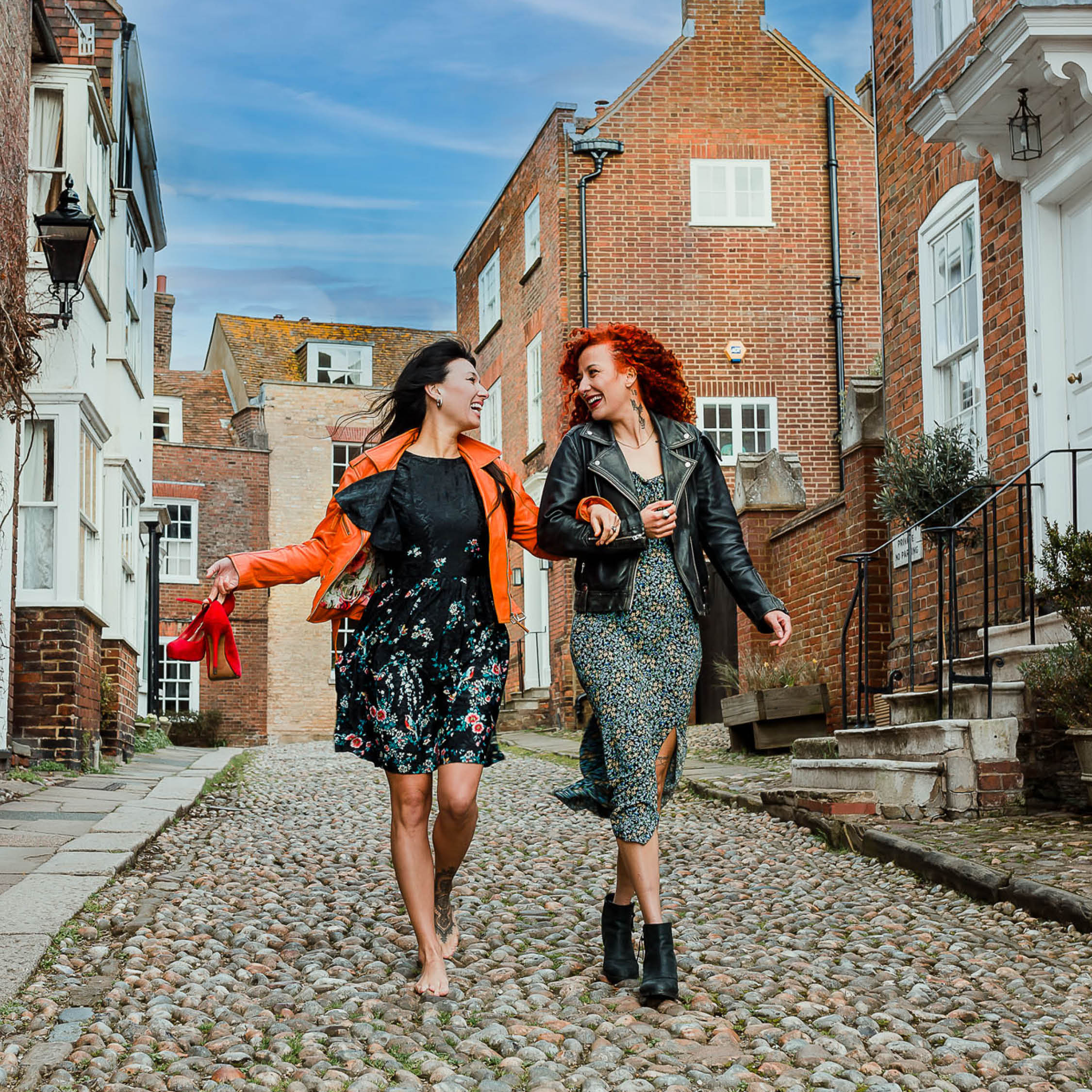 Two women walking down a cobbled street in Rye